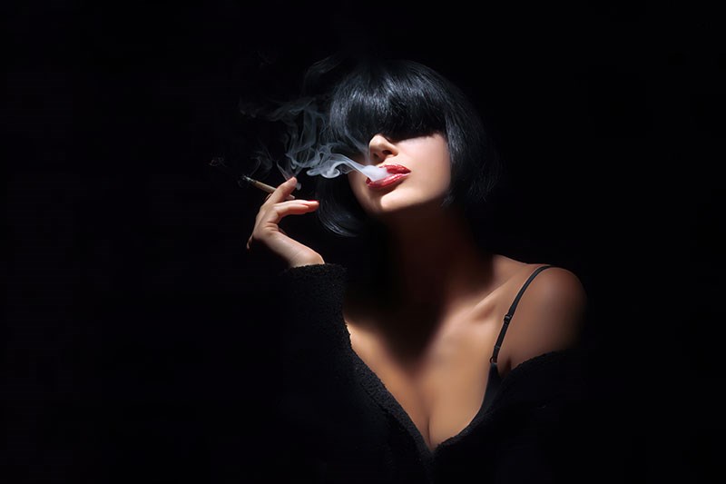 Mooie vrouw met zwart haar die sigaret rookt Behang