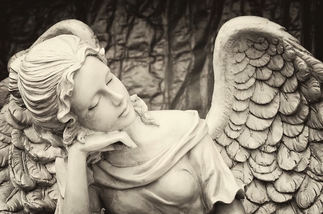 behang met vrouwelijk engelenstandbeeld als thema